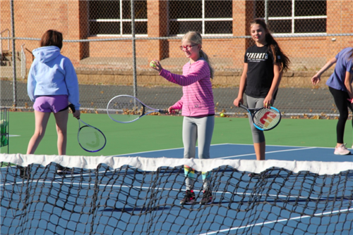 Girls playing tennis outdoors 